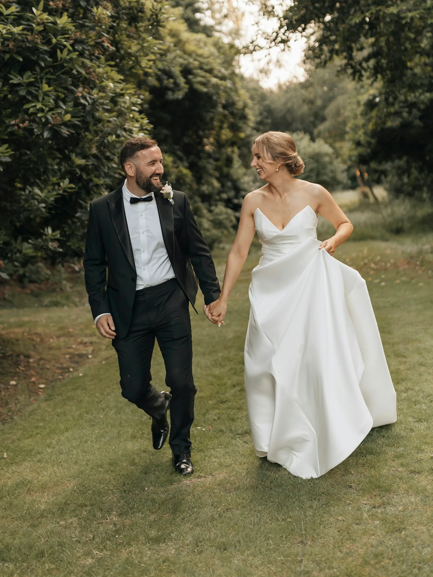 Inês and Tomás walking hand in hand across the lawn