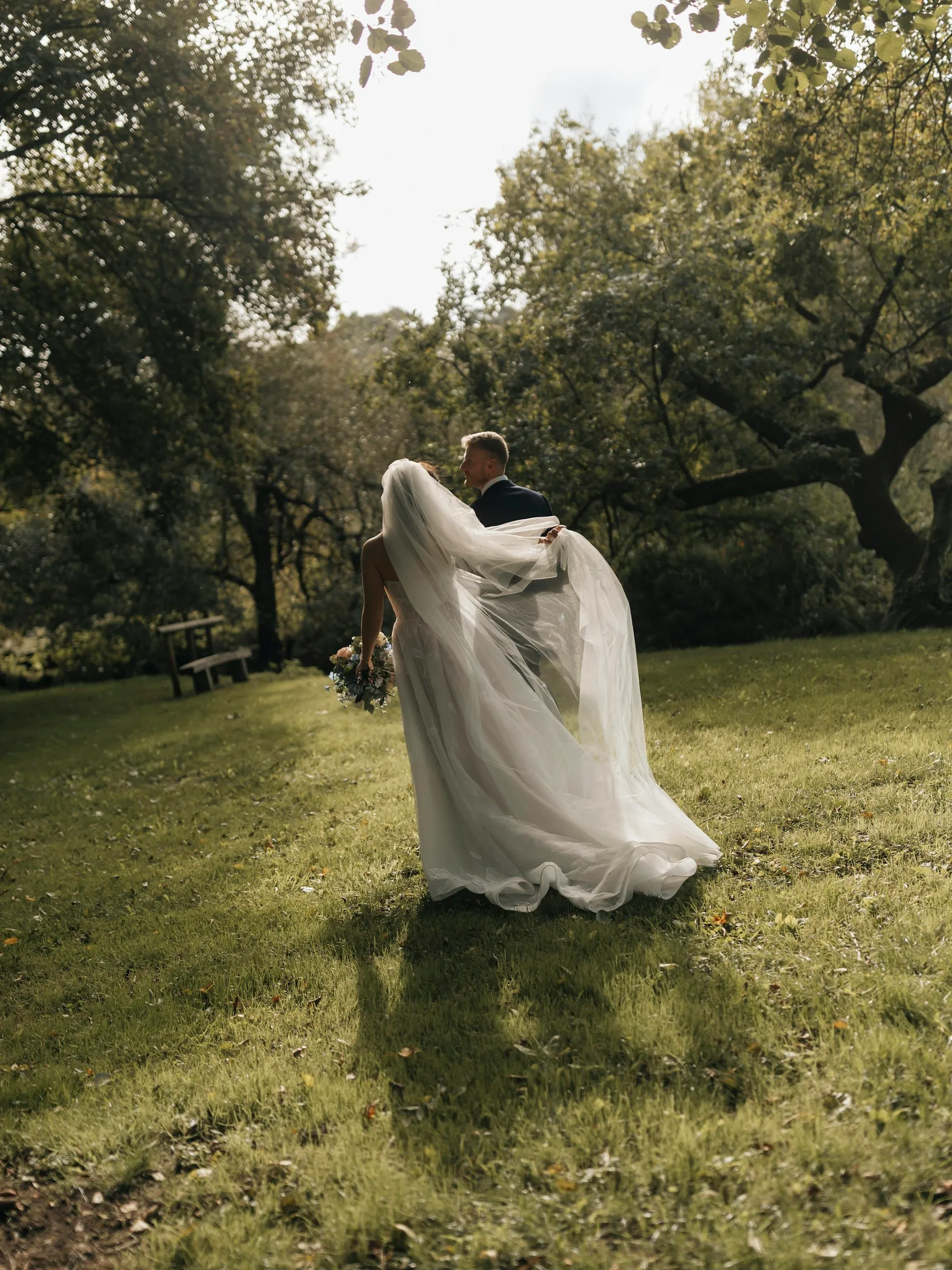 Inês lifting her dress as she runs towards the trees