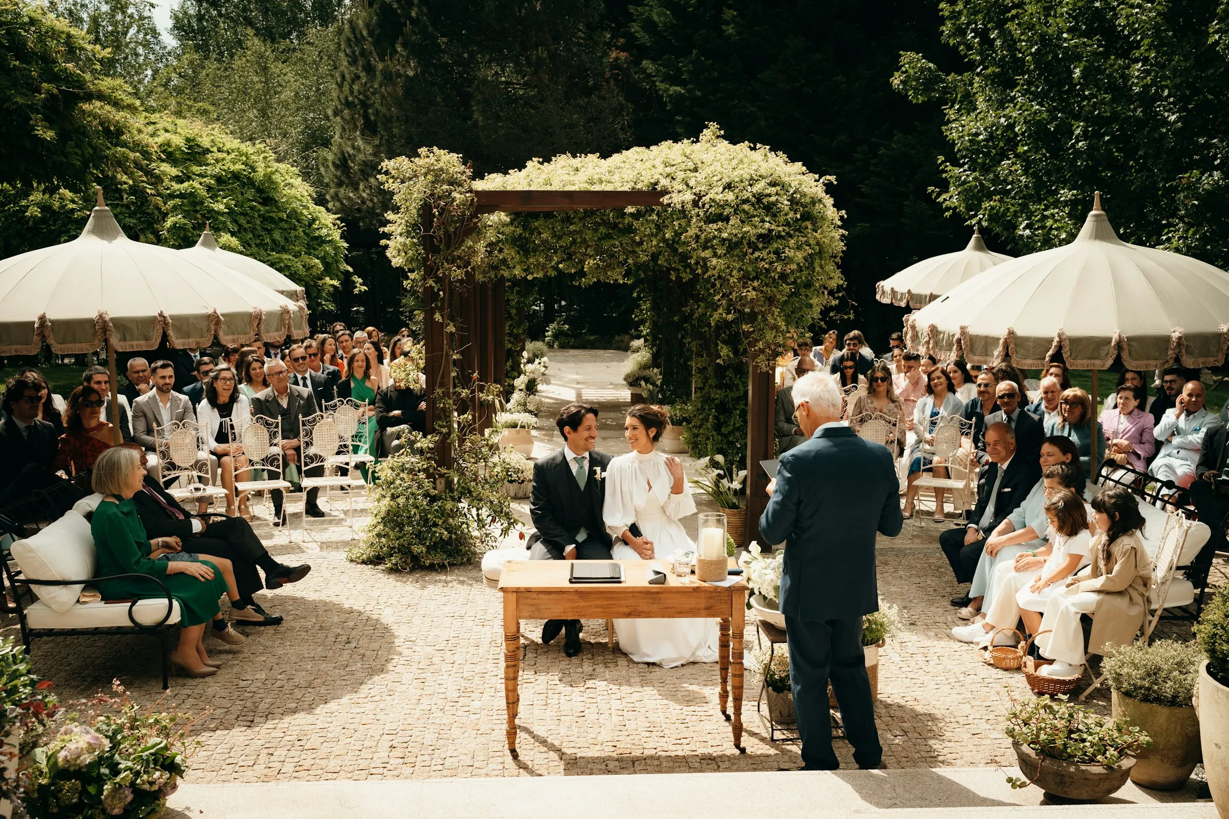 The garden ceremony under cream parasols