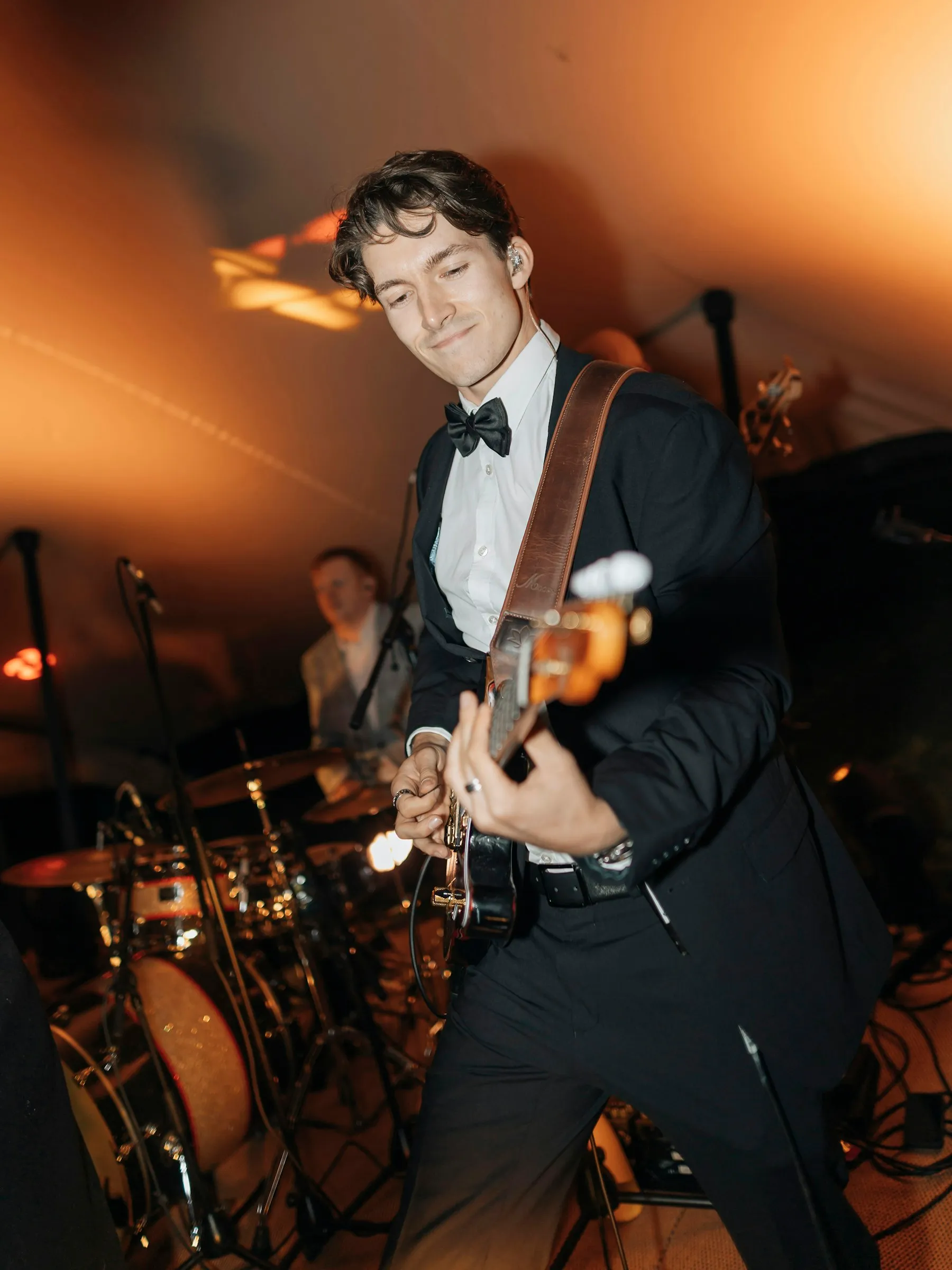 A guitarist playing under warm lights