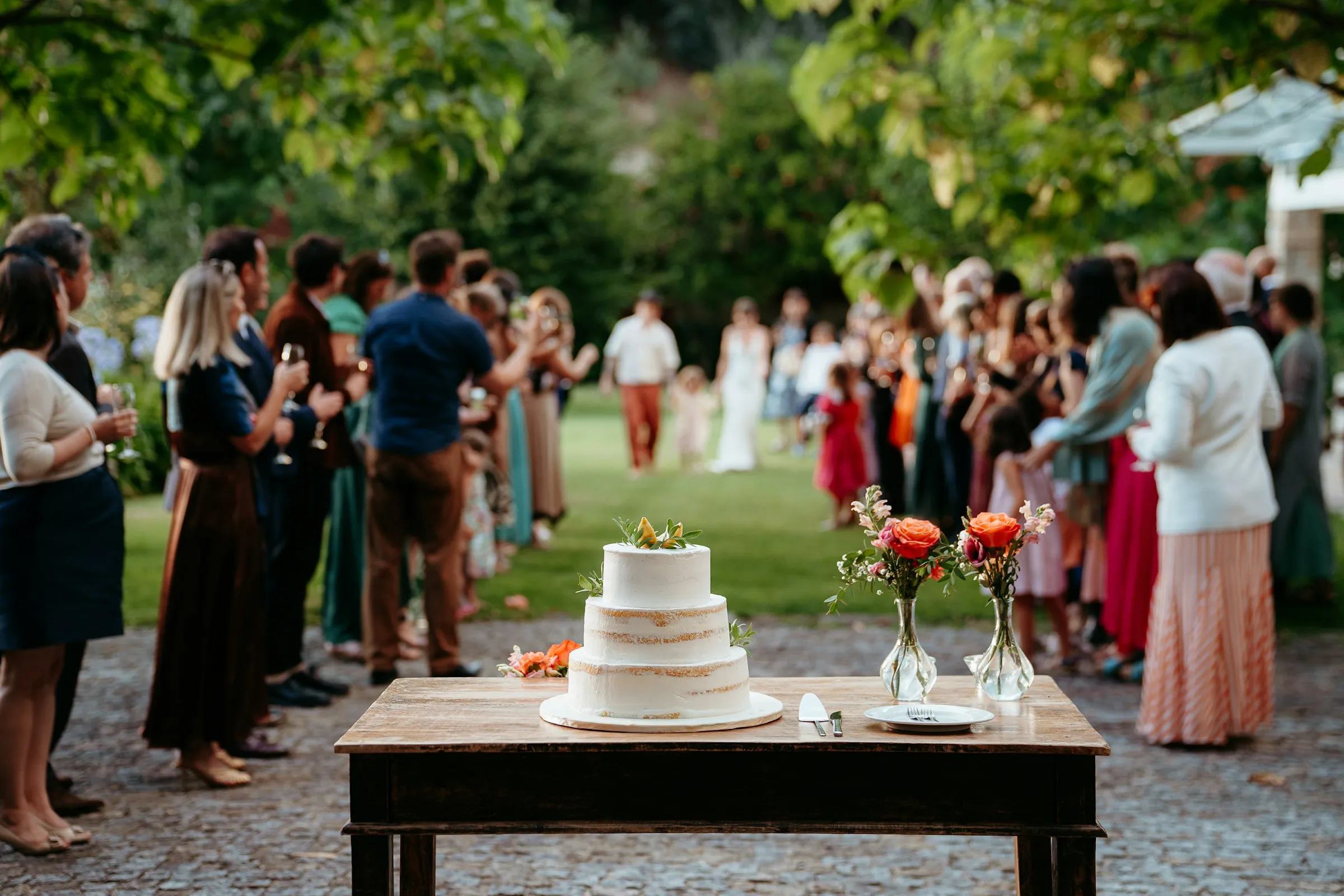 Guests gathered around the cake in the garden