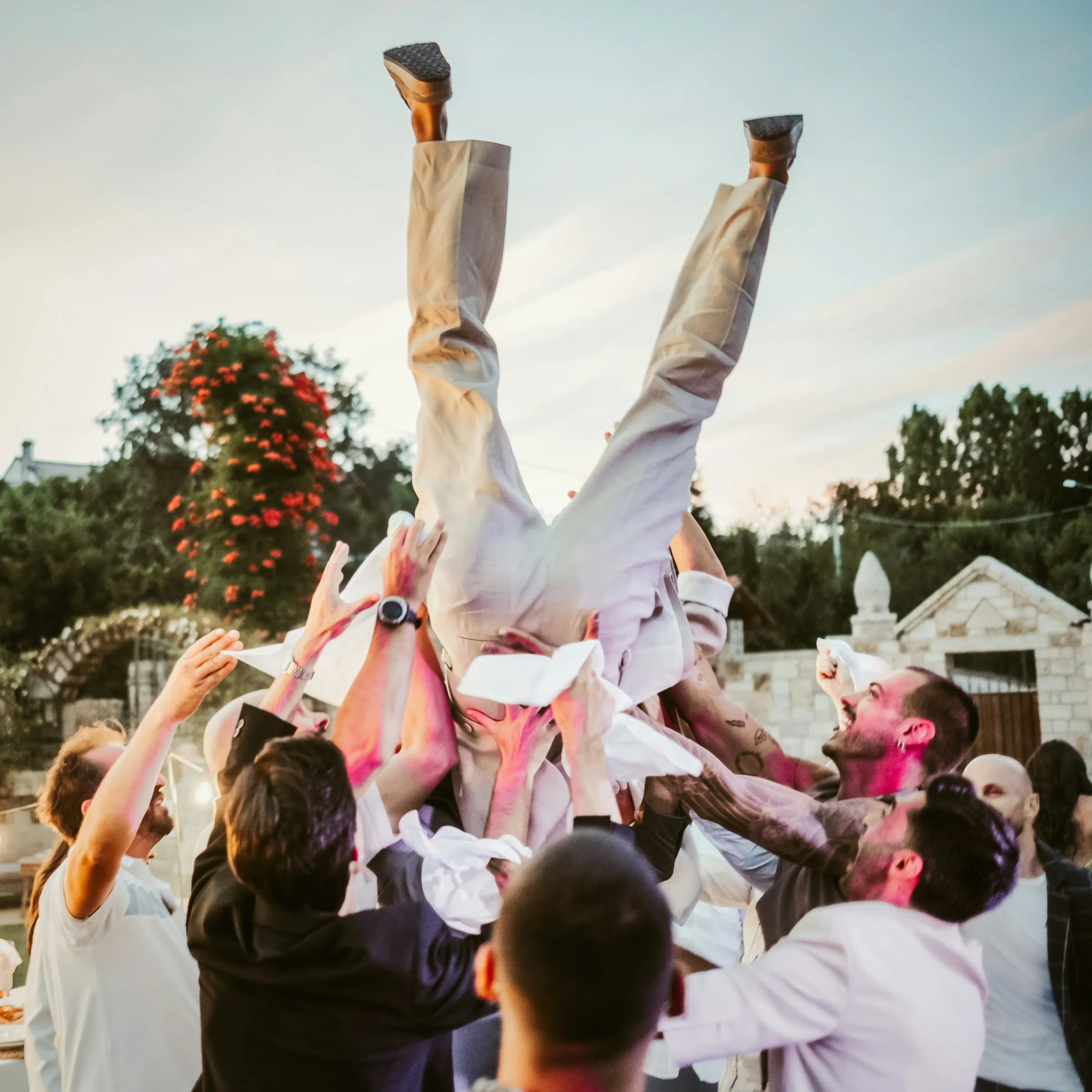 Groomsmen throwing the groom in the air