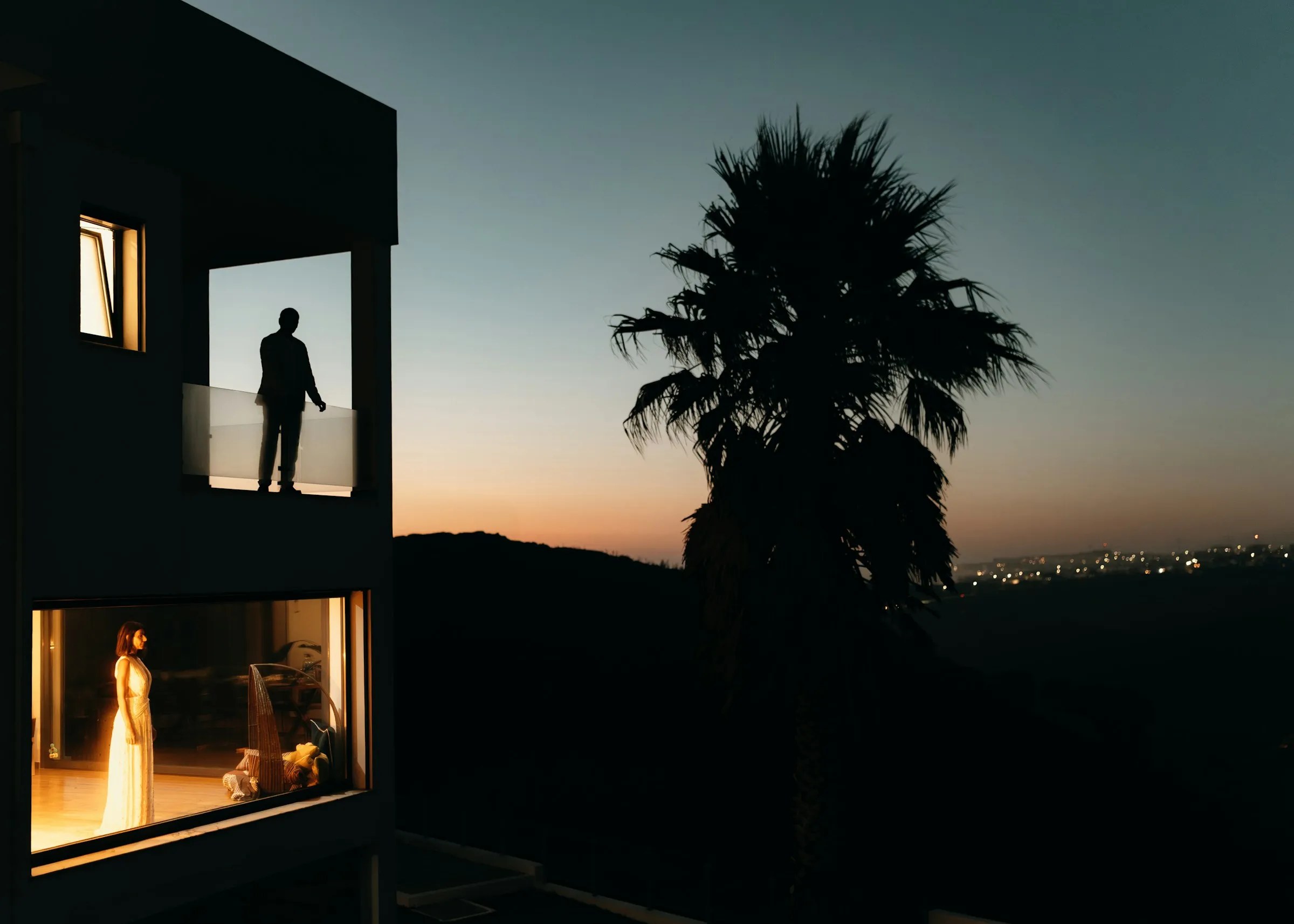 The house at dusk, lights on in the windows