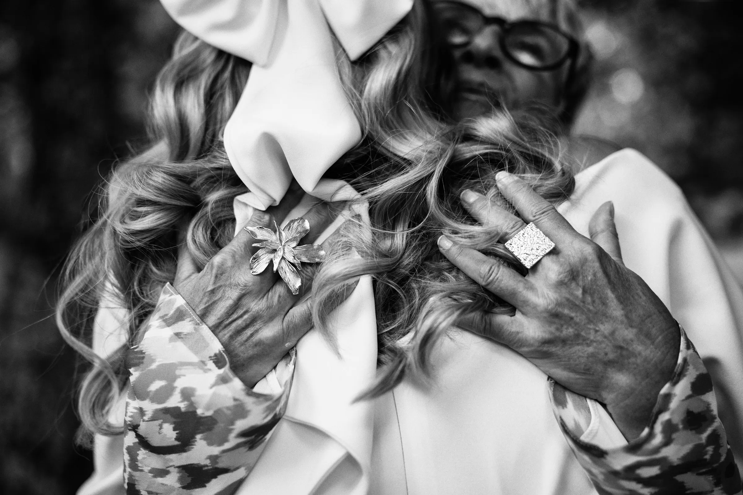Black and white detail of a grandmother’s hands during an embrace