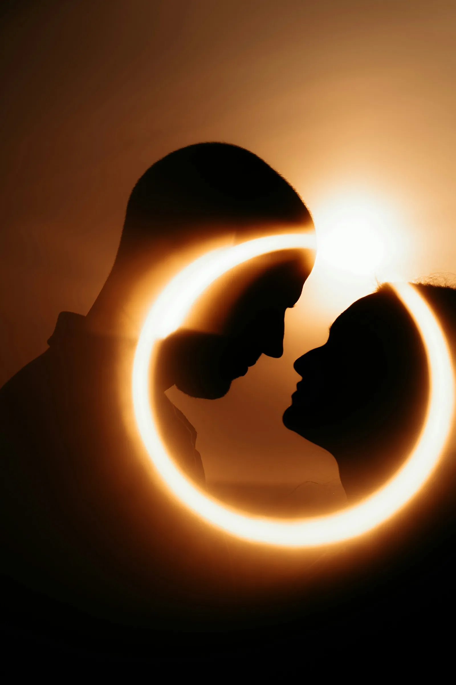Two silhouettes inside a ring of light