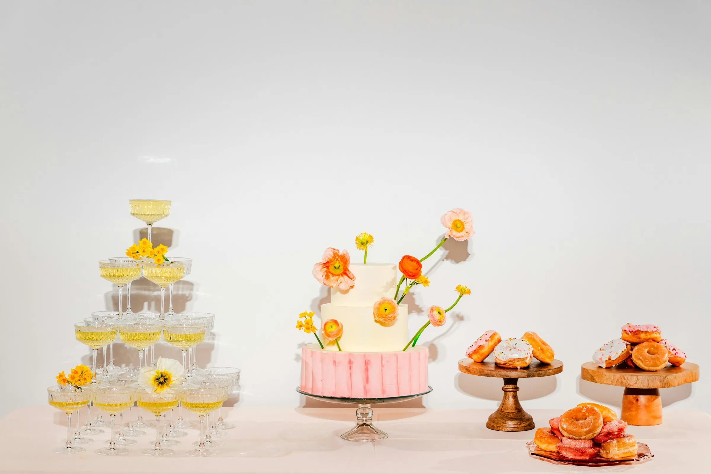The cake and champagne coupes on a white table