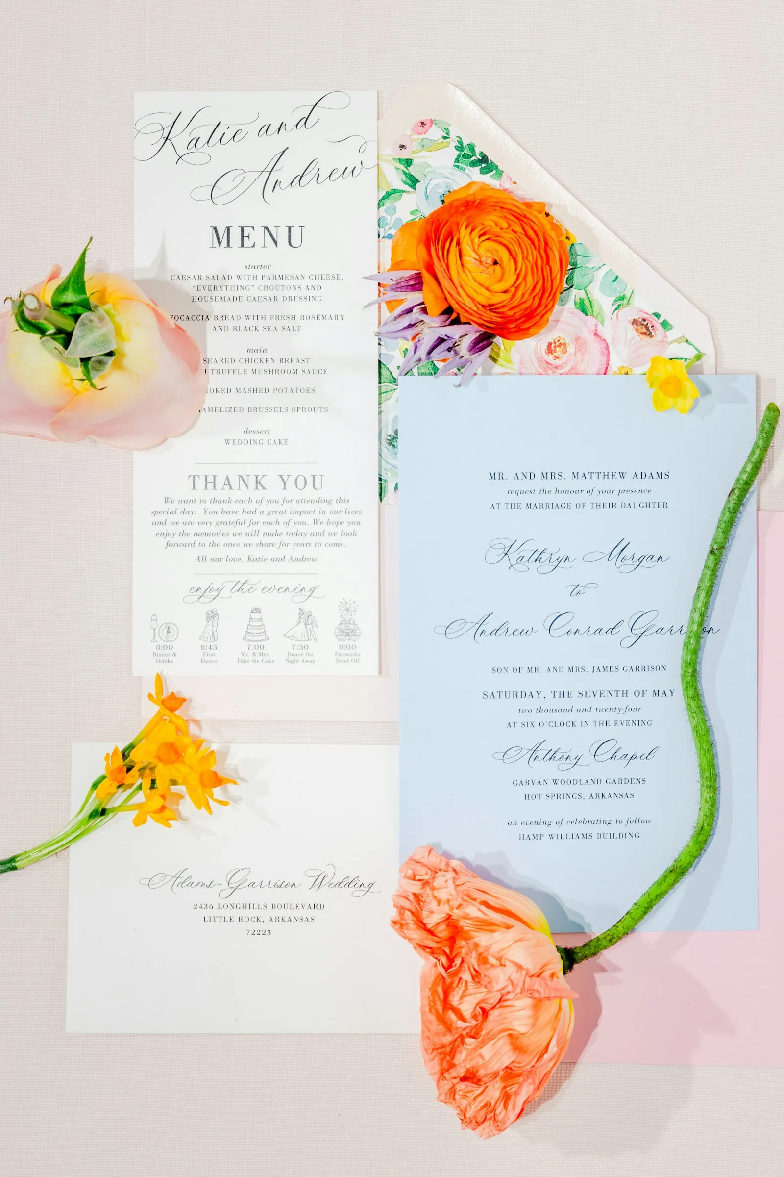 Wedding stationery and an orange ranunculus